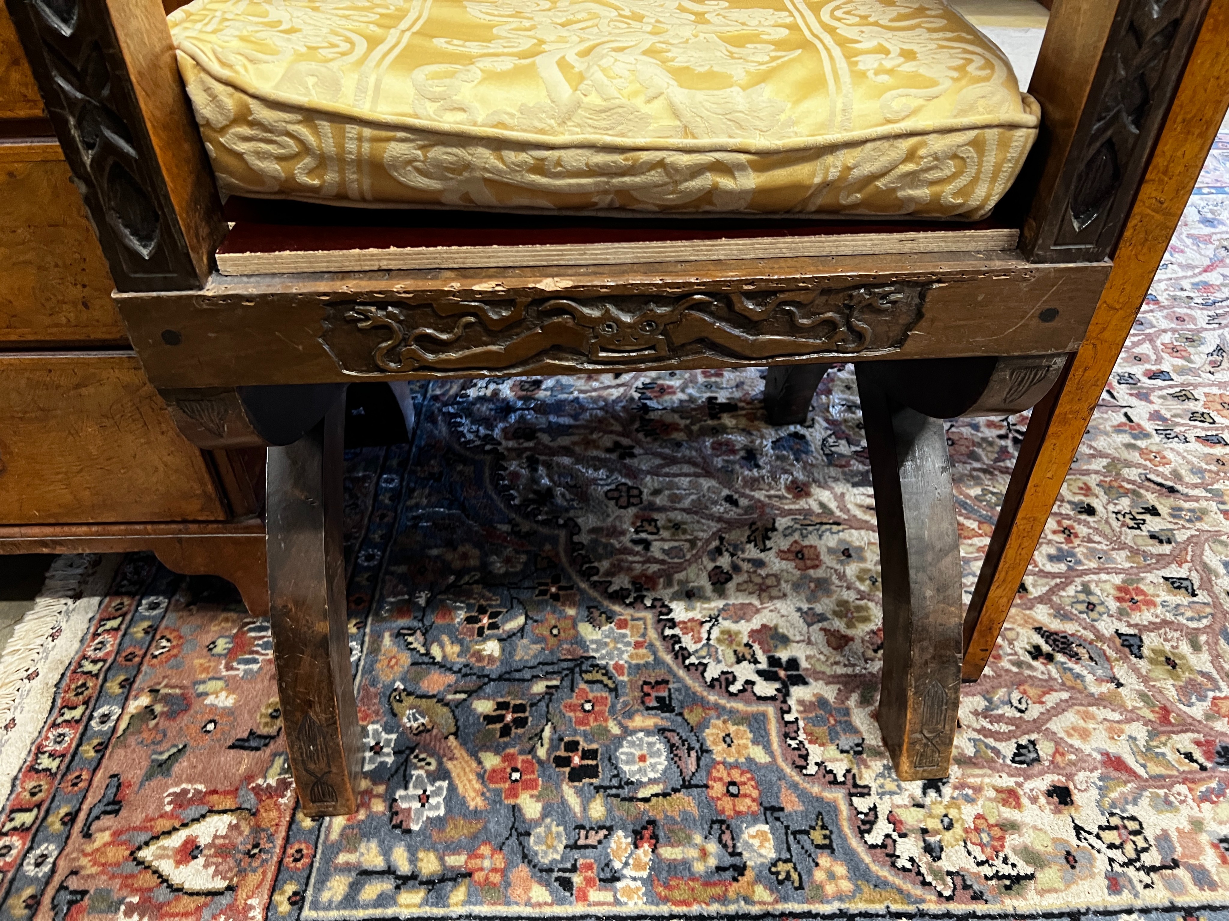 A 17th century style carved oak X-frame elbow chair with carved owl and figural motifs, width 58cm, depth 50cm, height 105cm